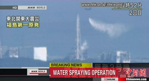 图为直升机向福岛第一核电站三号机组注水过程的电视截图。